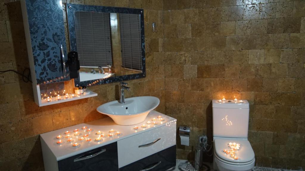 a bathroom with a sink and a toilet with christmas lights at Castle Nolana in Geredeli