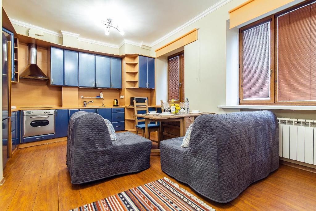 モスクワにあるDream House Plyushchikhaのキッチン(青いキャビネット、椅子2脚、テーブル付)