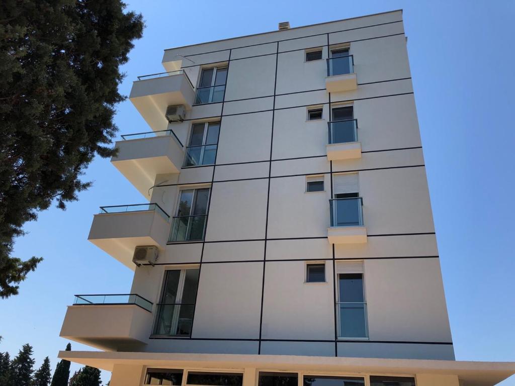 un edificio alto y blanco con ventanas. en Rasi Luxury Apartments en Ulcinj