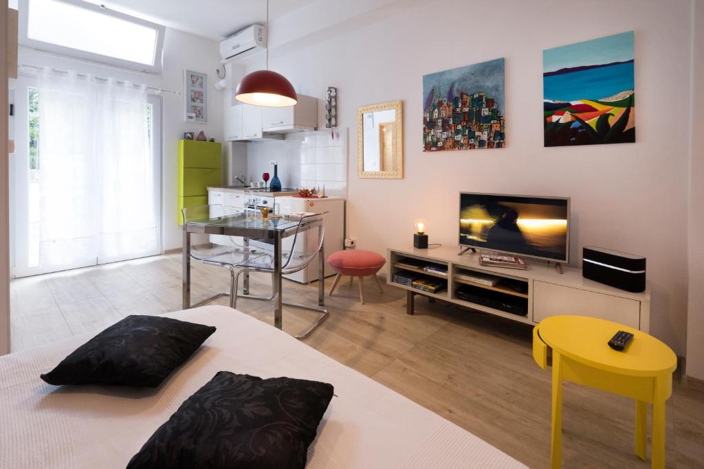 uma sala de estar com uma cama, uma televisão e uma mesa em Ayre Apartman Split em Split