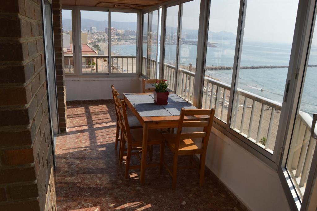 een tafel en stoelen op een balkon met uitzicht op de oceaan bij Apartment first line beach El Campello (Alicante) in El Campello