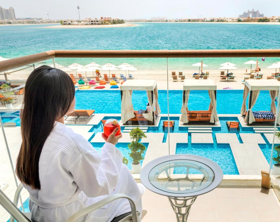 a woman sitting on a cruise ship holding an apple at Royal Central Hotel and Resort The Palm in Dubai