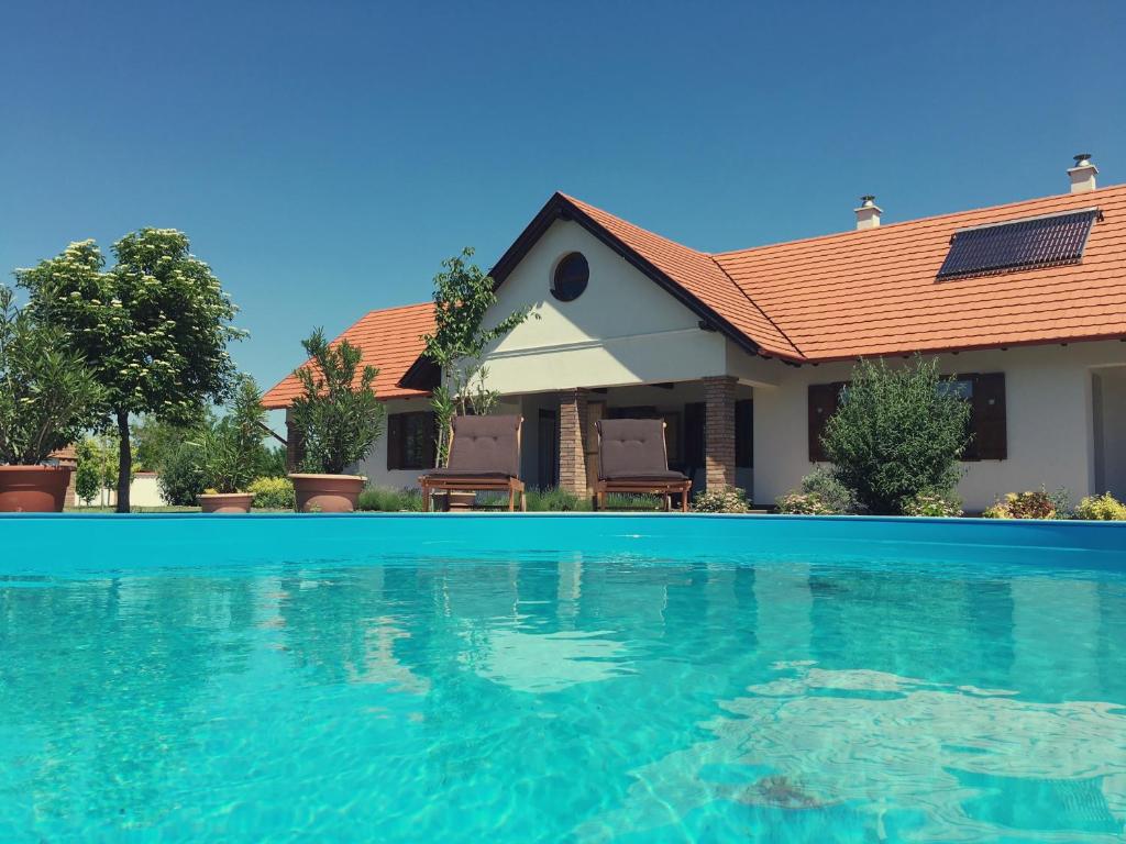 a house with a swimming pool in front of it at Kamillaház in Poroszló