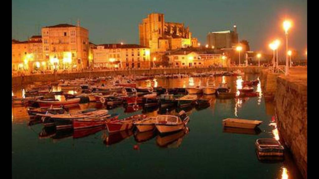 a group of boats docked in a harbor at night at Castro Sun And Beach in Castro-Urdiales