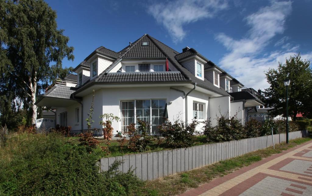 a white house with a black roof at Anna in Ostseebad Koserow