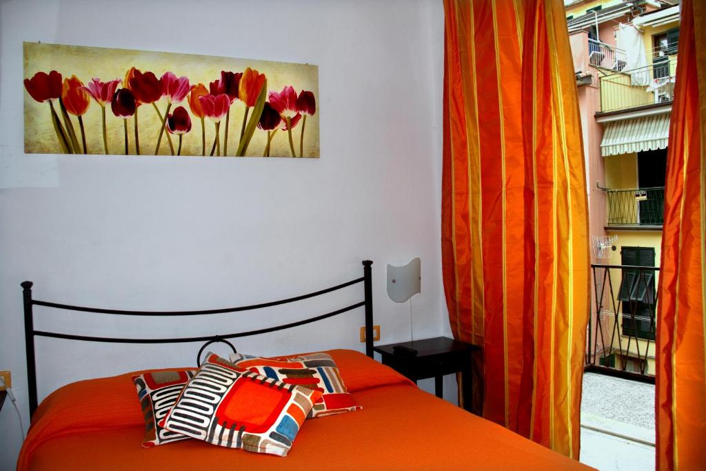 een slaapkamer met een bed en een schilderij van rode tulpen bij Affittacamere Rollando in Vernazza