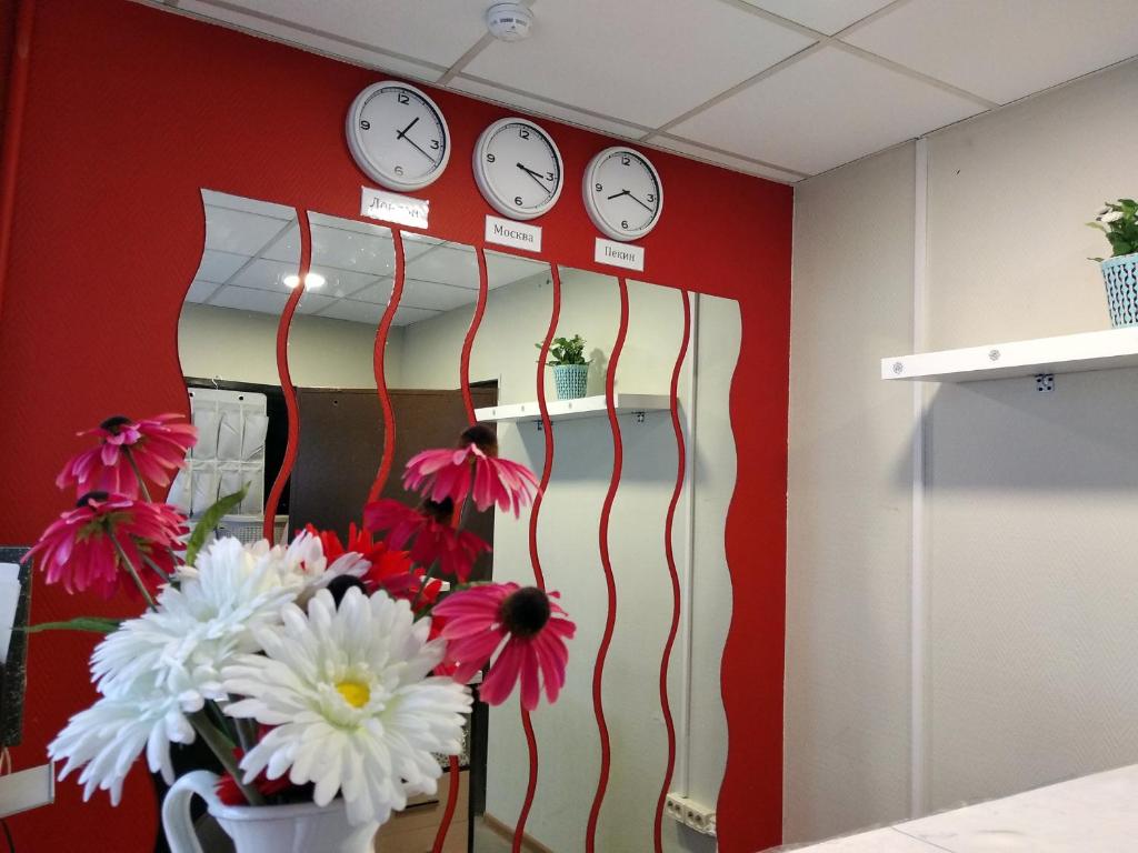 モスクワにあるRussland hostelの壁時計と花瓶付きの部屋