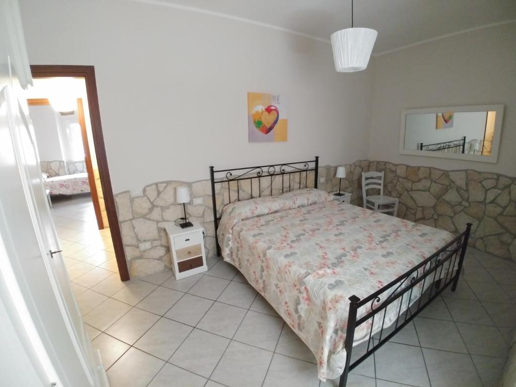 1 dormitorio con cama y pared de piedra en Tato home, en Alatri