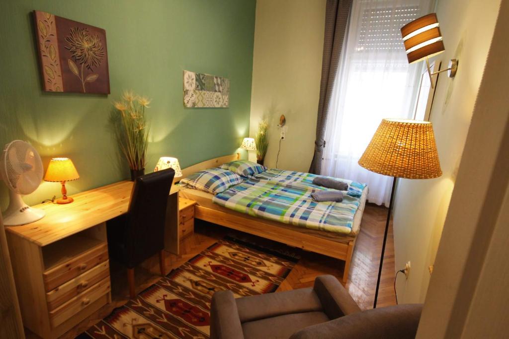 Habitación pequeña con cama y escritorio. en Pesto Hostel en Budapest