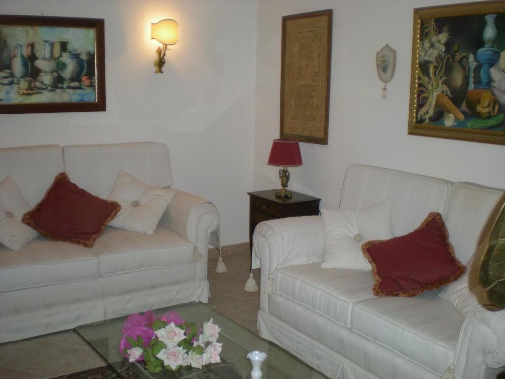 a living room with two white couches and a table at La Gardenia in Ioppolo Giancaxio