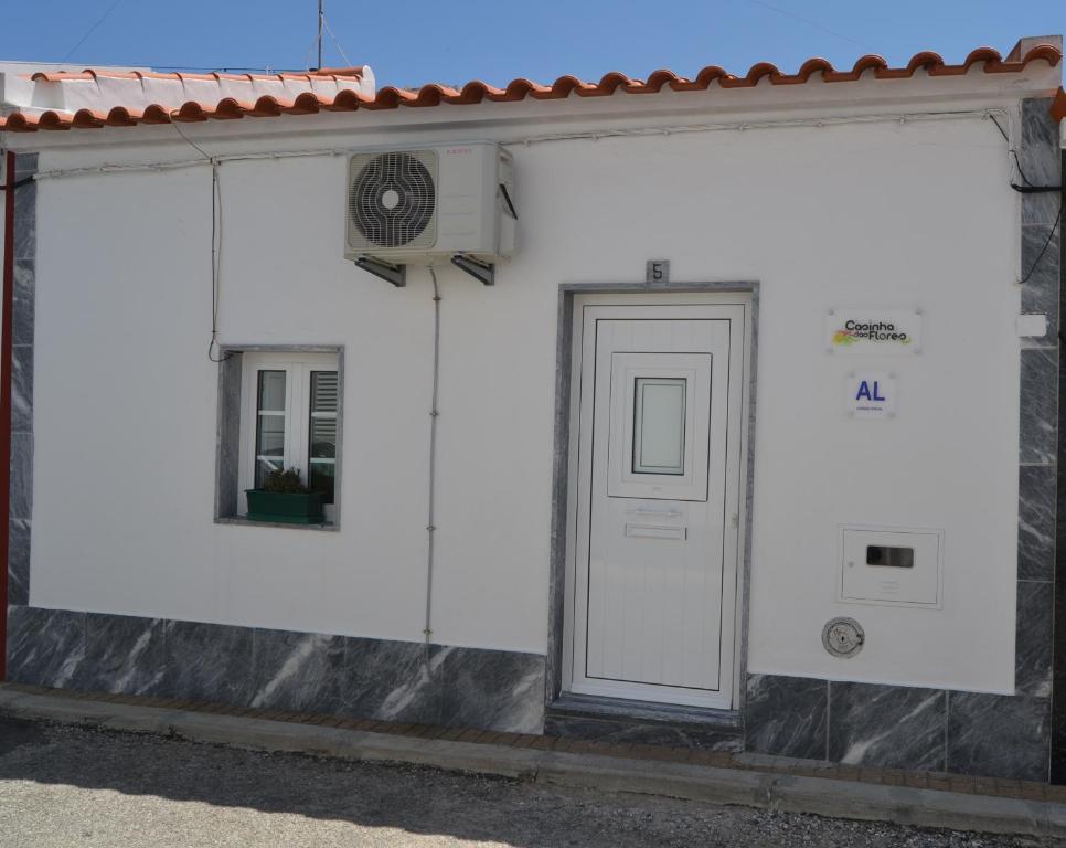 un edificio blanco con puerta y ventana en Casinha das Flores, en Reguengos de Monsaraz