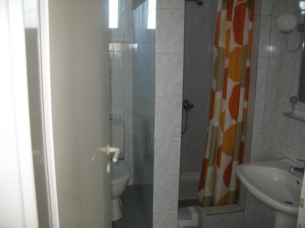 a bathroom with a shower and a toilet and a sink at Seaview Aparthotel in Nea Potidaea