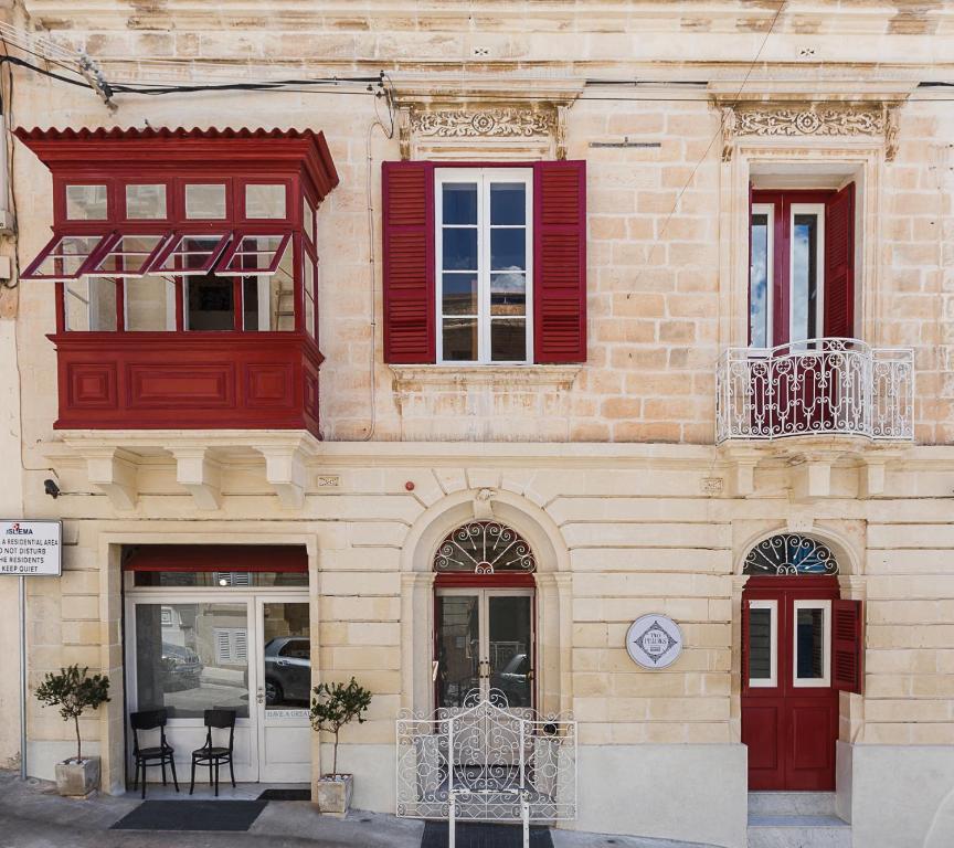 
a red brick building with a red door and windows at Two Pillows Boutique Hostel in Sliema
