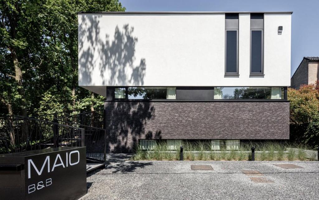 une maison moderne avec un panneau en face de celle-ci dans l'établissement MAIO B&B en Dinner, à Zonhoven