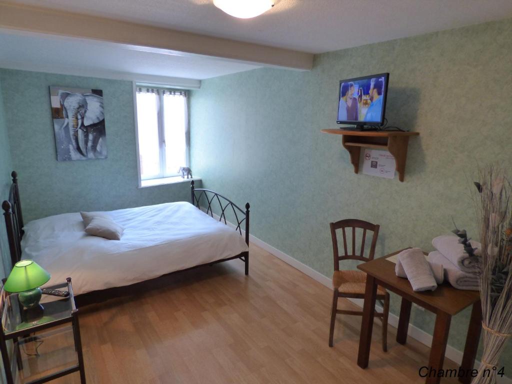 a bedroom with a bed and a table and a desk at Auberge Des Petits in Saint-Igny-de-Vers