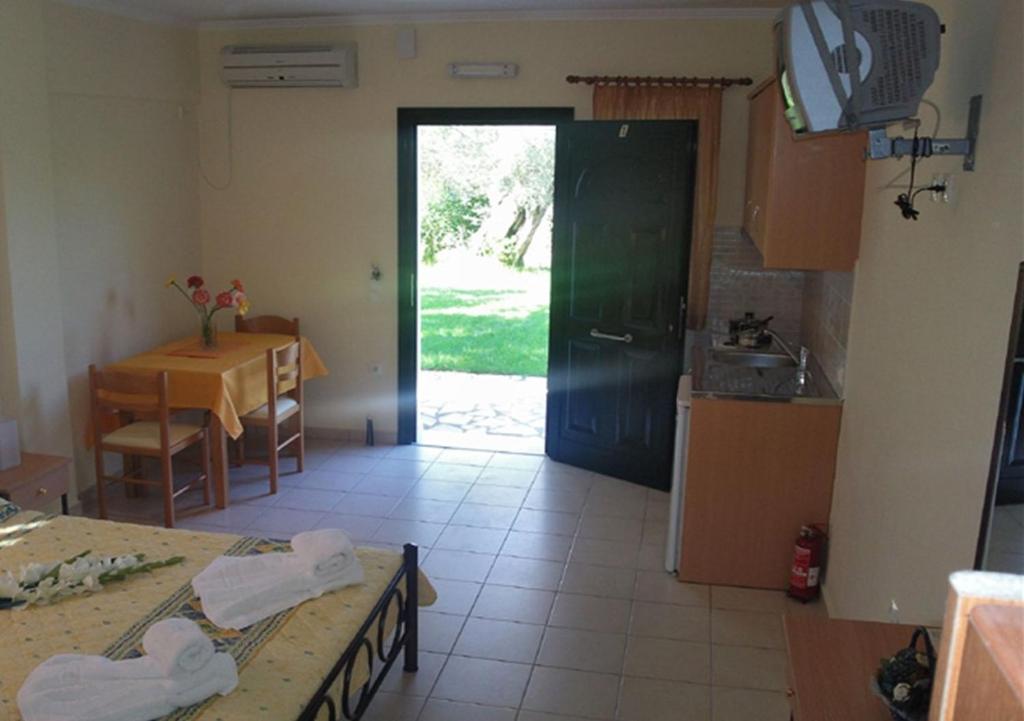 a kitchen with a door and a table and a dining room at Studios Niki B in Lefkada Town