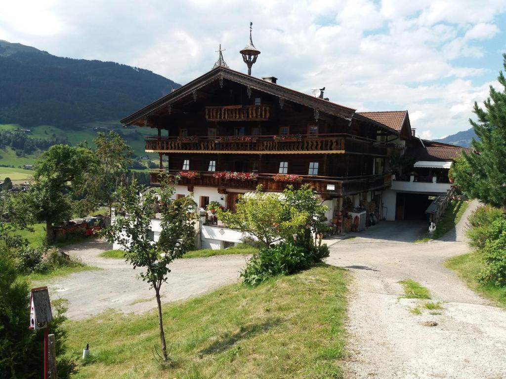 a large wooden building on a dirt road at Talhof in Jochberg