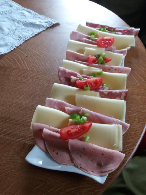 eine Gruppe Käse und Tomaten auf einem Teller auf dem Tisch in der Unterkunft Talhof in Jochberg