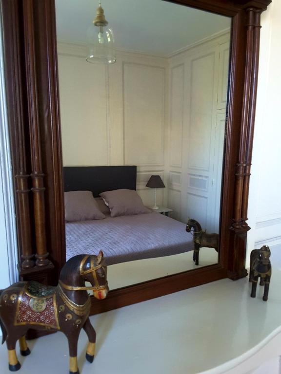 een slaapkamer met een standbeeld voor een spiegel bij La Maison des Thermes, Chambre d'hôte in Saintes