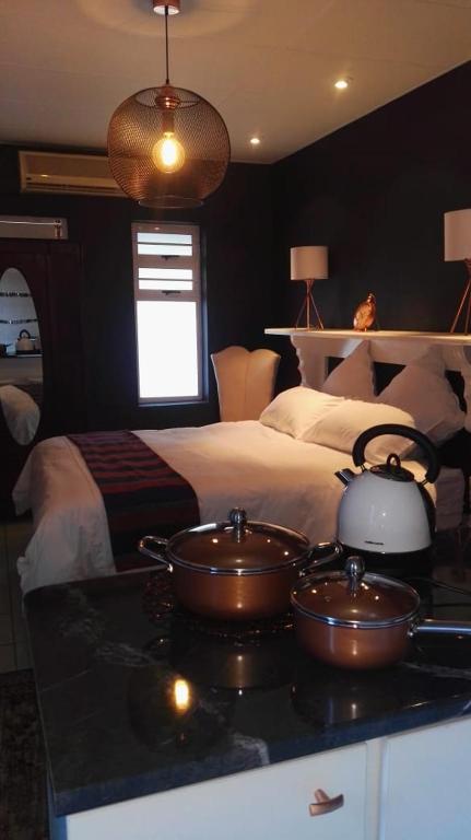 a bedroom with two bowls on a counter with a bed at Dankbaar in Bloemfontein