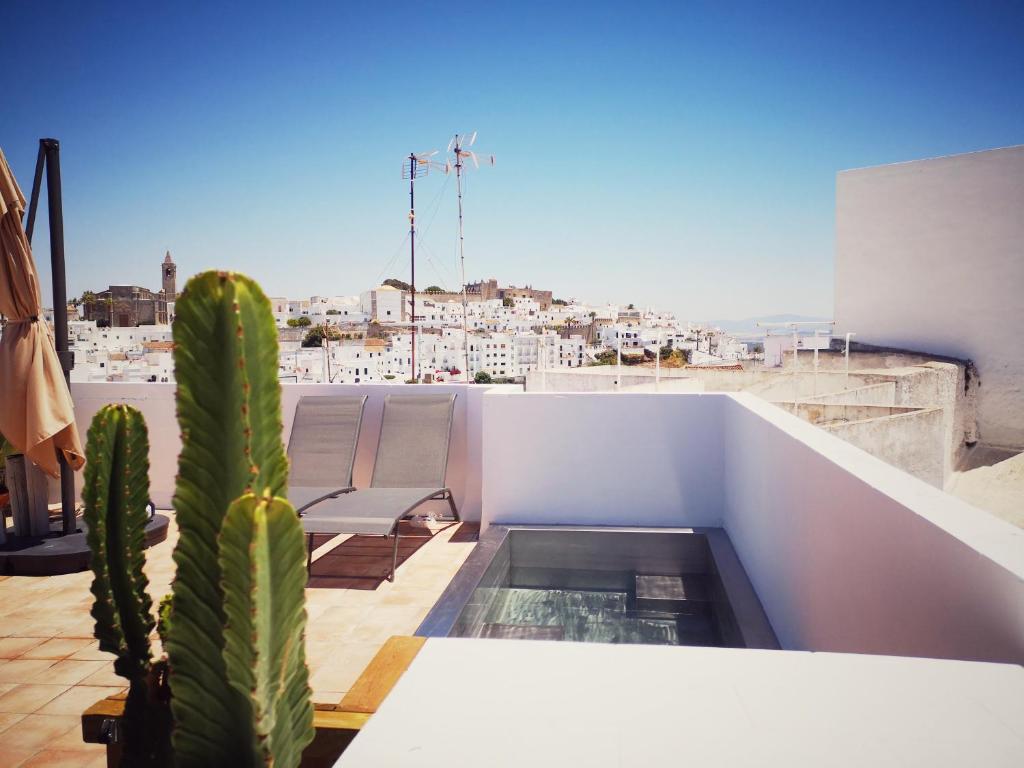 un balcón con un cactus y sillas en el techo en La Zalamera, en Vejer de la Frontera