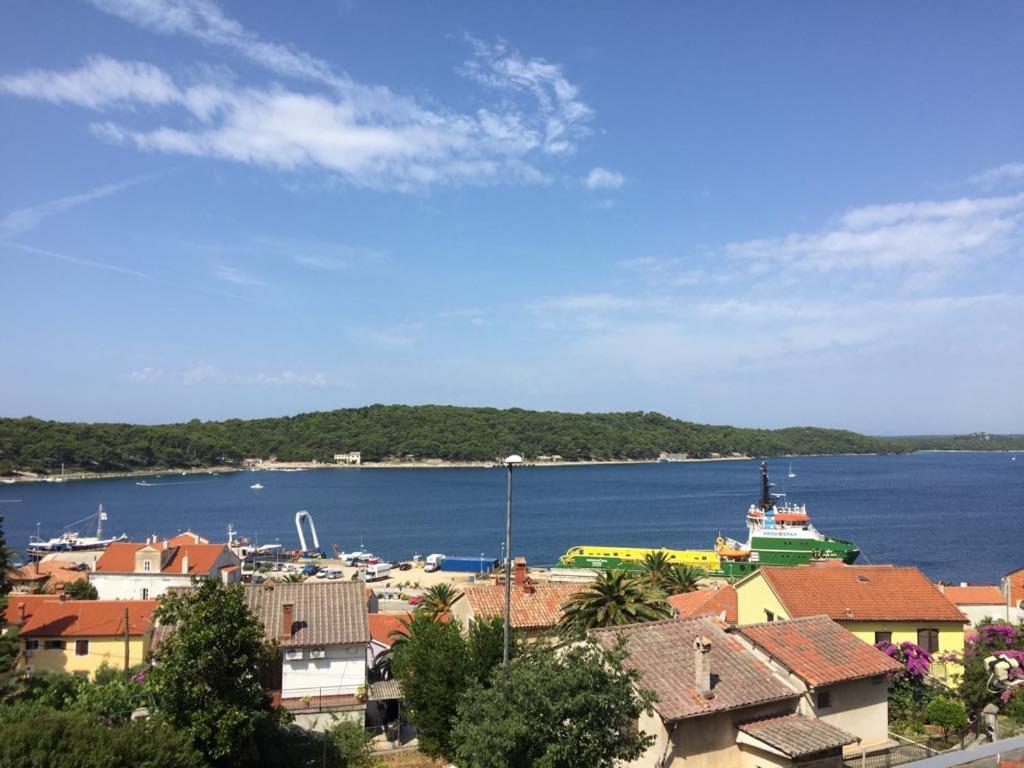 a view of a city with a boat in the water at Apartment Subota in Mali Lošinj