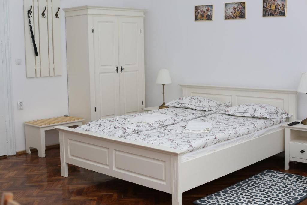 a white bedroom with a white bed and a white cabinet at Schick apartment in Sibiu
