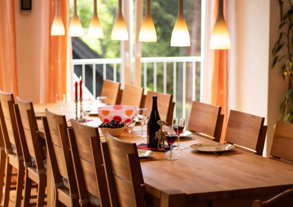 una larga mesa de madera con sillas y una botella de vino en Ferienwohnung Lochenblick, en Balingen