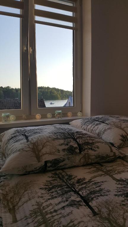 łóżko z 2 poduszkami w pokoju z 2 oknami w obiekcie Apartament ULA w mieście Mikołajki