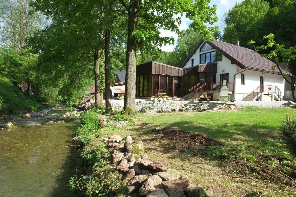 une maison avec une rivière devant elle dans l'établissement Wellness privát Štyri Lipy, à Liptovské Revúce