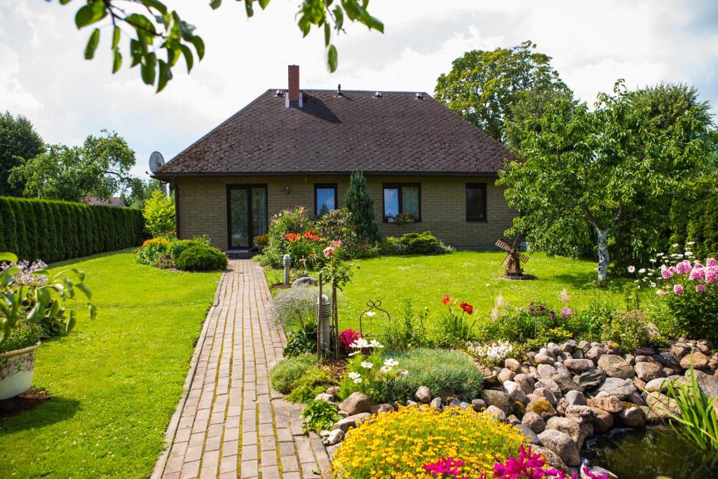 a house with a garden and a brick walkway at Guests house "Like Home" in Sigulda