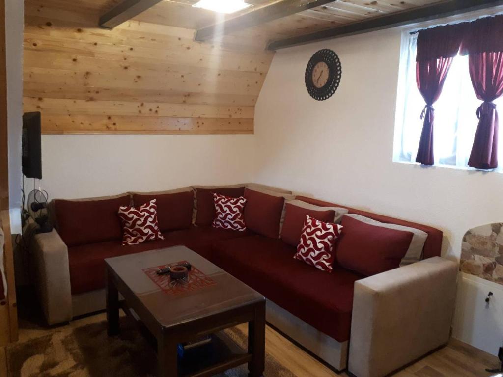 ein Wohnzimmer mit einem Sofa und einem Tisch in der Unterkunft House SUN Z&B in Žabljak