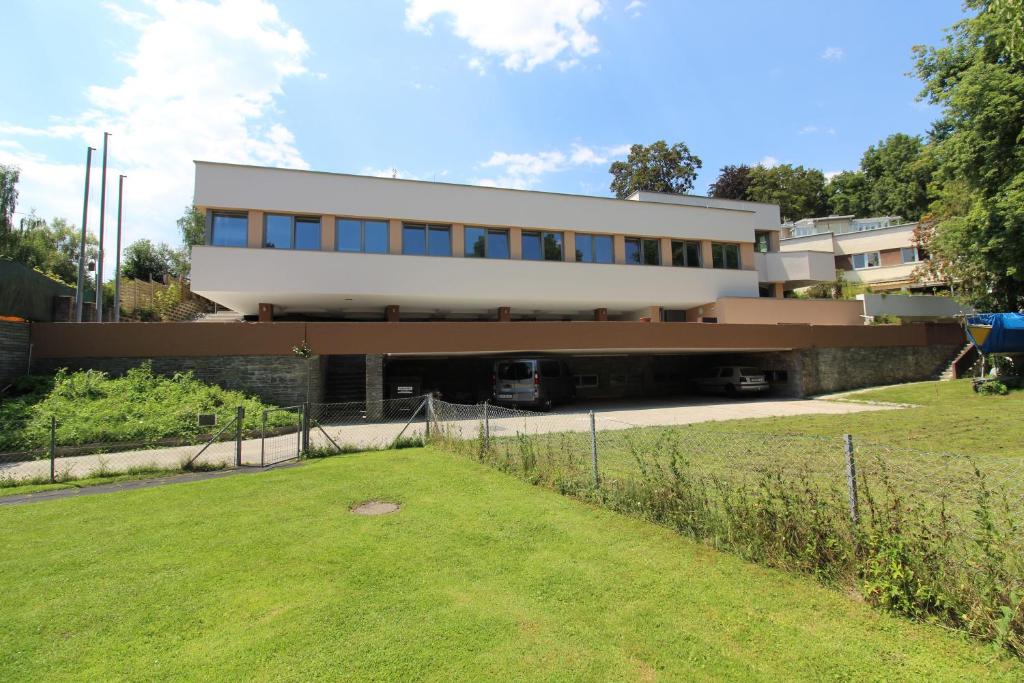 un grand bâtiment avec une pelouse devant lui dans l'établissement HeRo´s Home, à Klagenfurt am Wörthersee