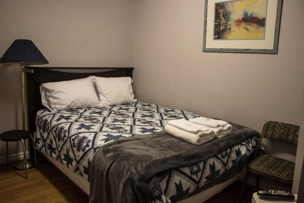 a bedroom with a bed with two towels on it at Saint Lawrence Residences and Suites in Toronto