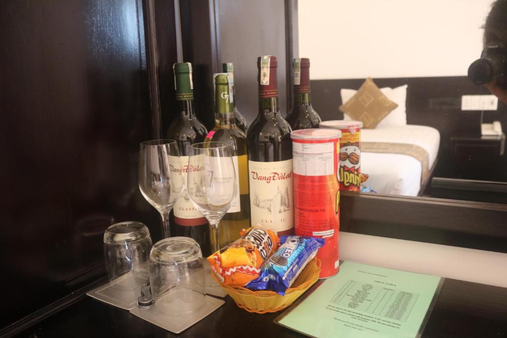 a group of wine bottles and glasses on a table at Golden Bell Homestay in Hoi An