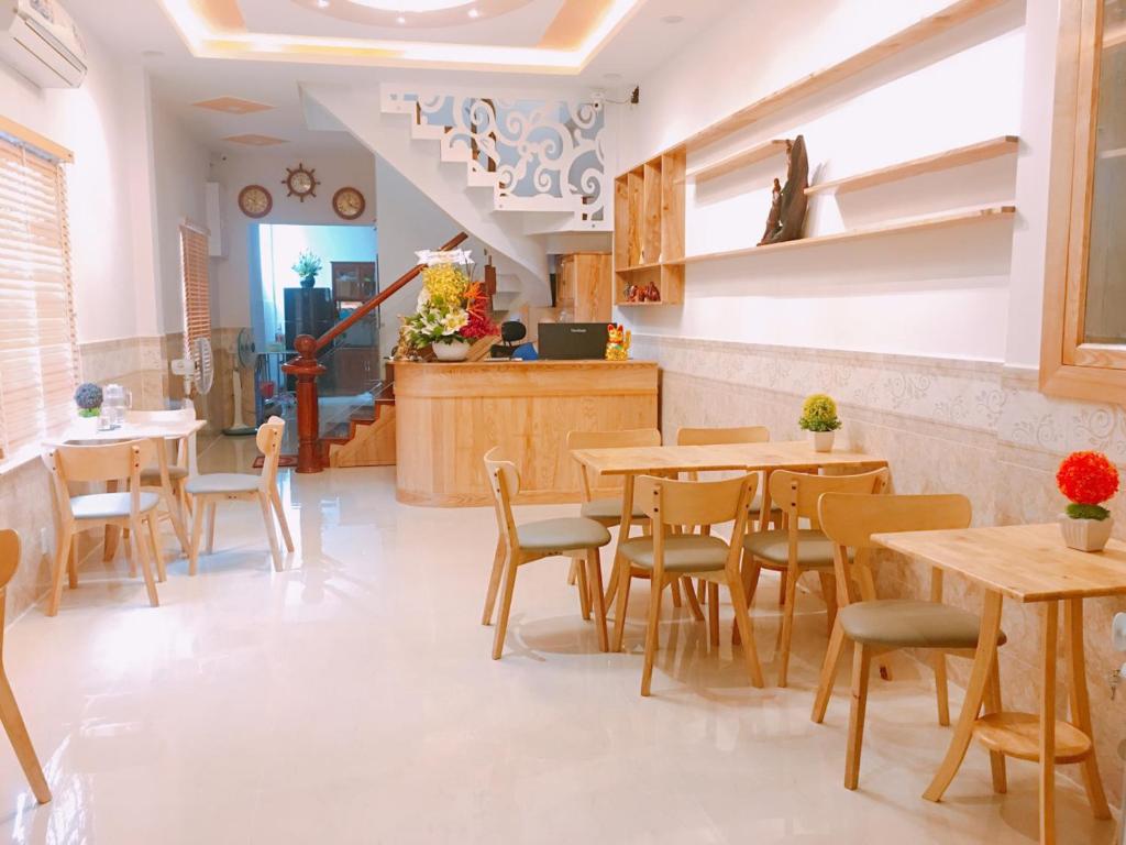 a restaurant with tables and chairs in a room at Tomorrow Hostel Vũng Tàu - Tomorrow Homestay in Vung Tau
