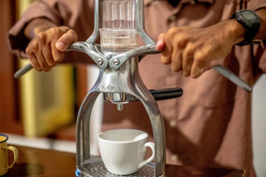 a man is pouring coffee into a coffee maker at Snooze in Yogyakarta