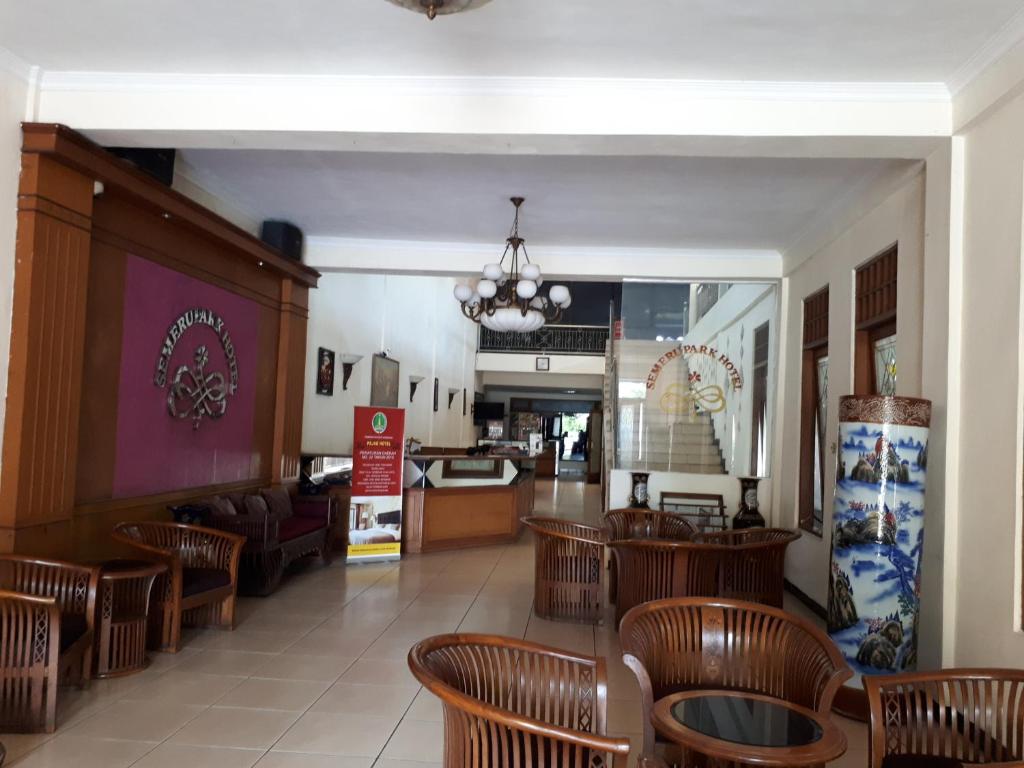a restaurant with wooden tables and chairs in a room at Semeru Park Hotel in Pasuruan