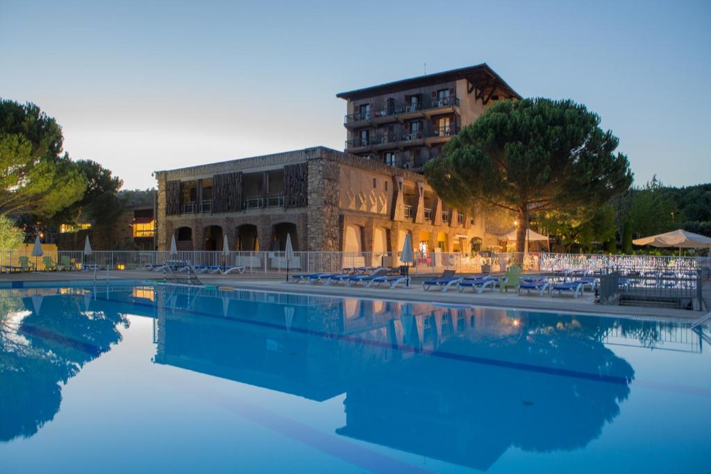 a swimming pool in front of a building at ULVF Hôtel Castel Luberon in Apt