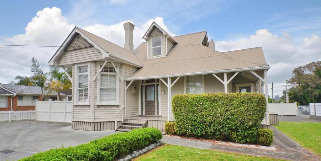 una casa con un seto verde delante de ella en Regent Residential Villa, en Whangarei