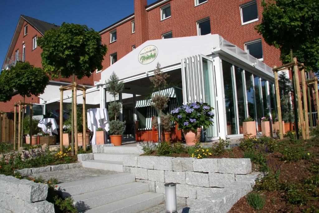 a store front of a brick building with flowers at Hotel & Restaurant Fricke in Hämelerwald