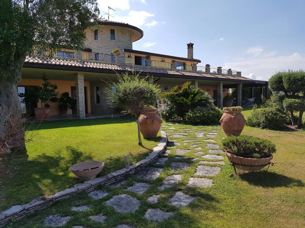 een huis met drie grote vazen in de tuin bij B&B Villa Moen in Fossacesia