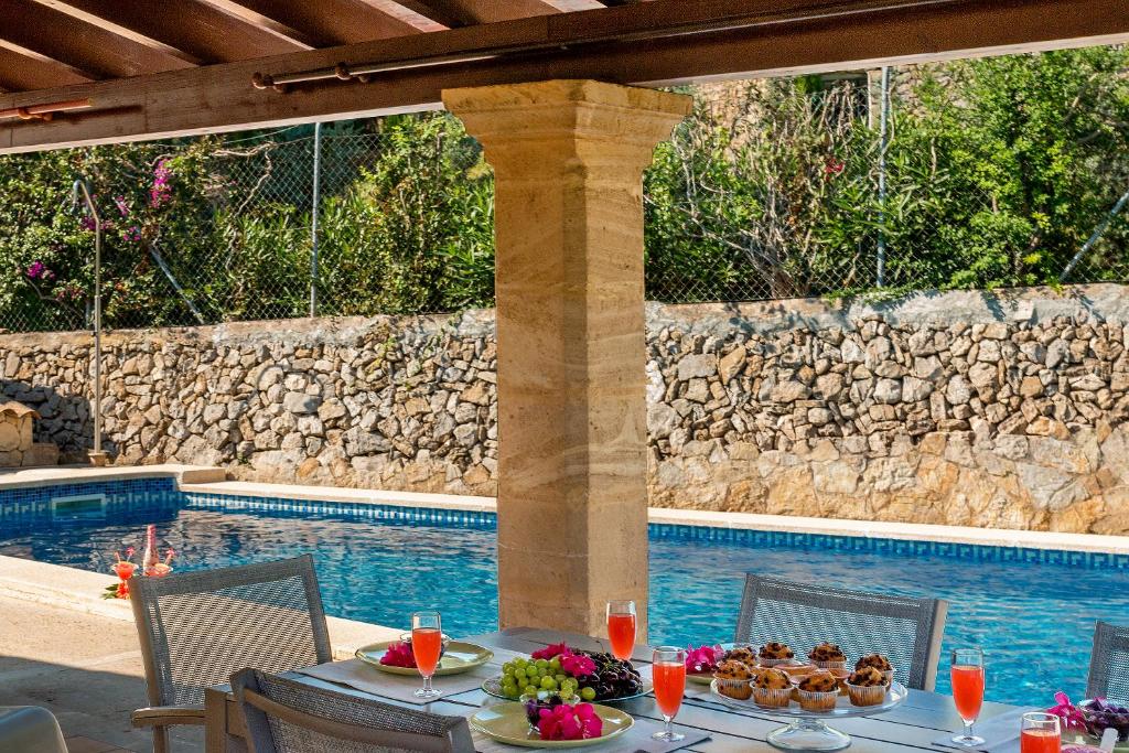 - une table avec de la nourriture à côté de la piscine dans l'établissement Villa Malva, à Alcúdia