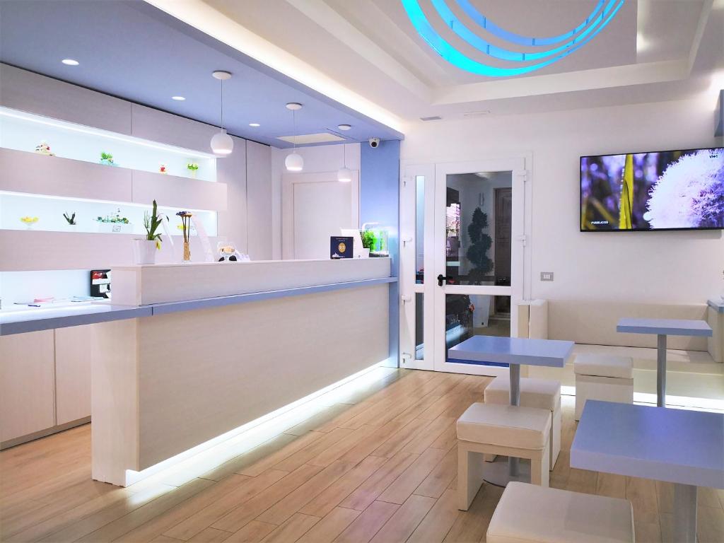 a restaurant with a counter and tables and chairs at Hotel Perla Gaia in San Vito lo Capo