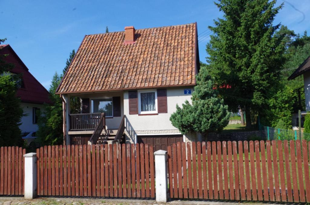 ビルカシにあるDomek letniskowyの褐色の屋根の柵の裏の家