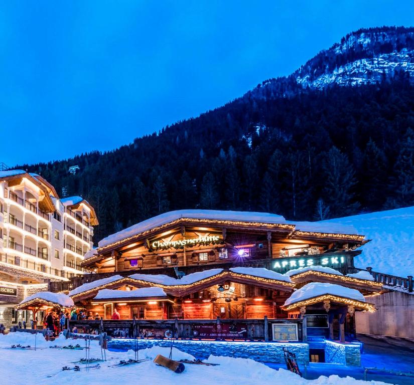 a large building in the snow in front of a mountain at Schlosshotel Ischgl 5-Sterne Superior in Ischgl