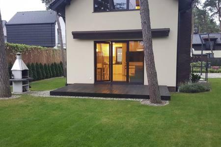 a house with glass doors in a yard at Hire House in Pobierowo