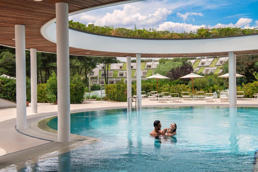 duas pessoas na piscina de um hotel em Ethra Reserve Kalidria em Castellaneta Marina