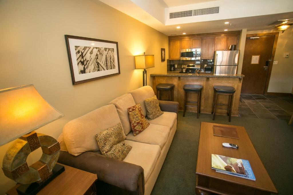a living room with a couch and a kitchen at Sundial Lodge Condo Steps from Red Pine Gondola in Park City