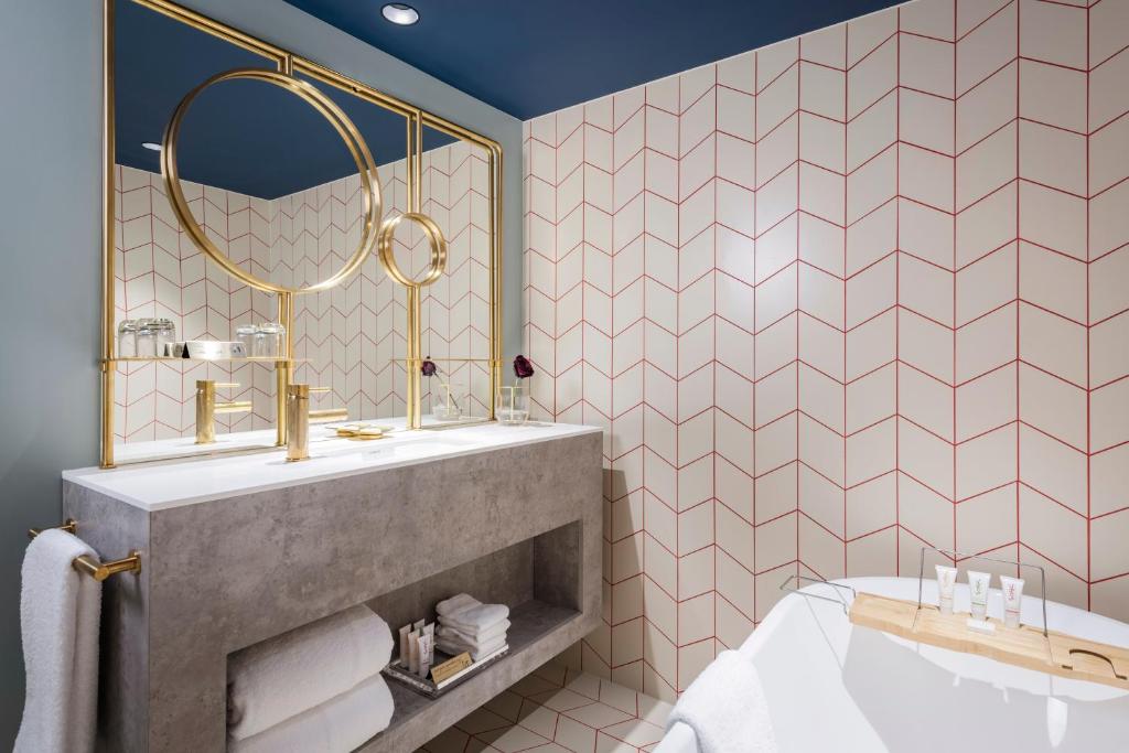 a bathroom with a sink and a tub at Naumi Auckland Airport Hotel in Auckland